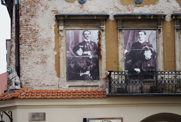 In zwei Fenstern eines alten Gebäudes in Lublins Altstadt wurden zwei alte Schwarz-Weiß Portraits von Paaren angebracht.