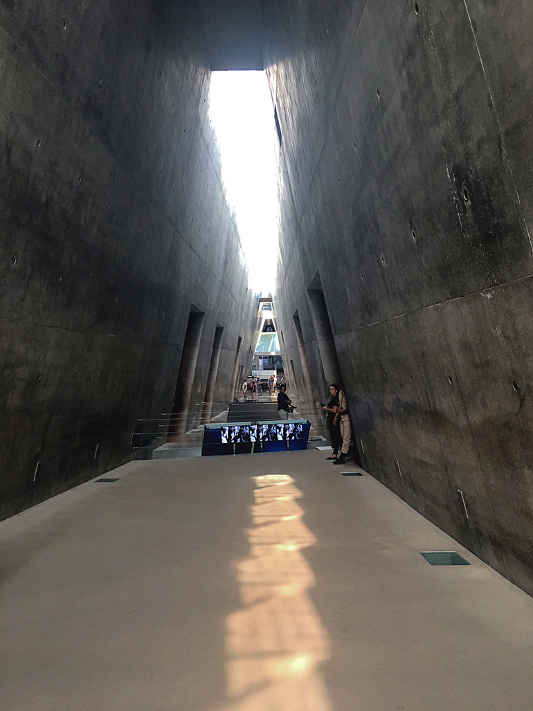 Der Weg durch das Holocaust Museum Yad Vashem in Jerusalem führt an hohen sich zuspitzenden Betonmauern entlang.