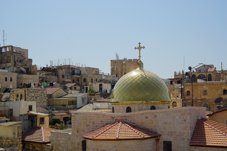 Die Sonne strahlt über den steinernen Gemäuer und einer goldenen Kuppel einer katholischen Kirche in Jerusalem, Israel.
