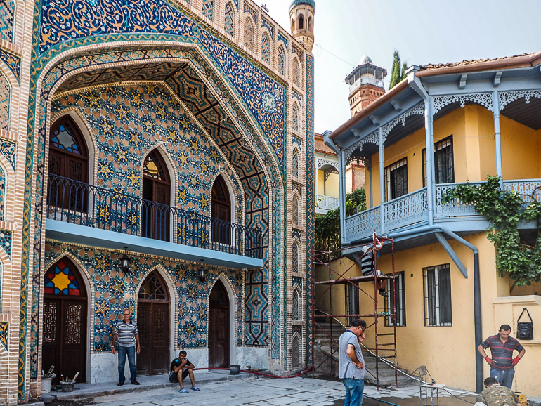 An einem Haus in Tiflis Bäderviertel Abanotubani zieren verschiedene Mosaikmuster die Front.