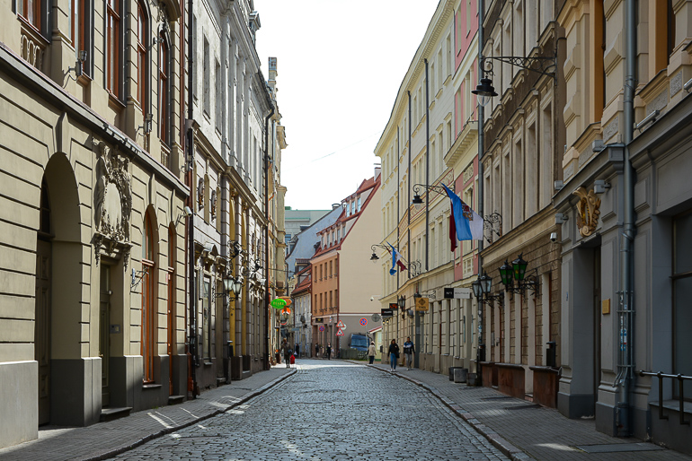 Eine kopfsteingepflasterte Gasse in Rigas Altstadt mit Blick auf die Kaufmannshäuser.