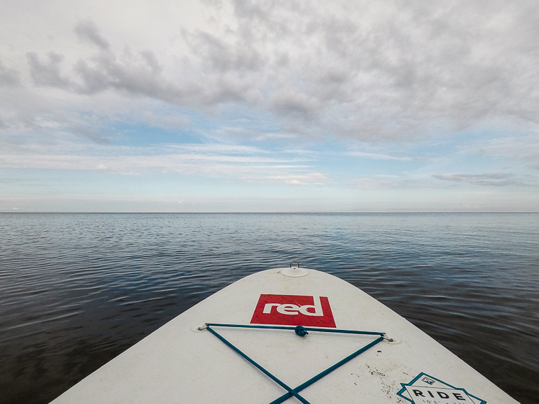 Ein SUP-Board gleitet über das Wasser der Ostsee an der Küste von Jurmala in Lettland.