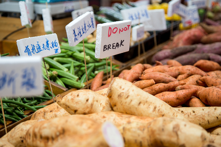 Victoria, Australien: Verschiedenes Gemüse wird auf dem Victoria Market zum Verkauf angeboten, manche Gemüsesorten sind mit chinesischen Schriftzeichen deklariert.