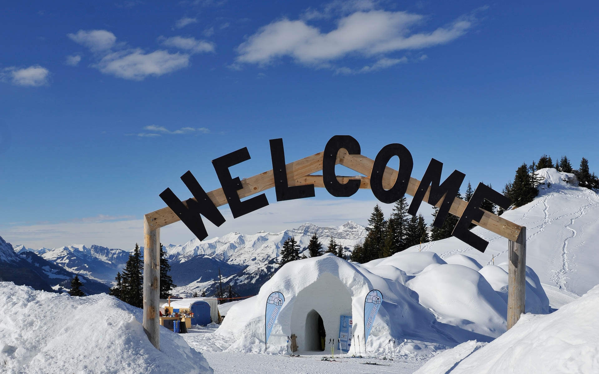 In einer Winterlandschaft steht bei strahlendem Sonnenschein ein großes Schild mit der Aufschrift Welcome