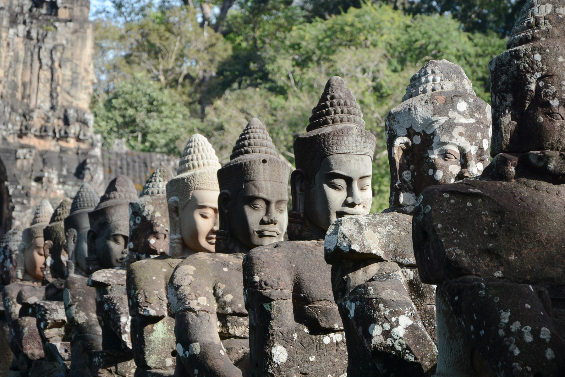 Riesige Buddha Statuen aus Stein stehen aneinandergereiht in Kambodscha auf der Rundreise von Pnom Penh nach Siem Reap, Angkor.
