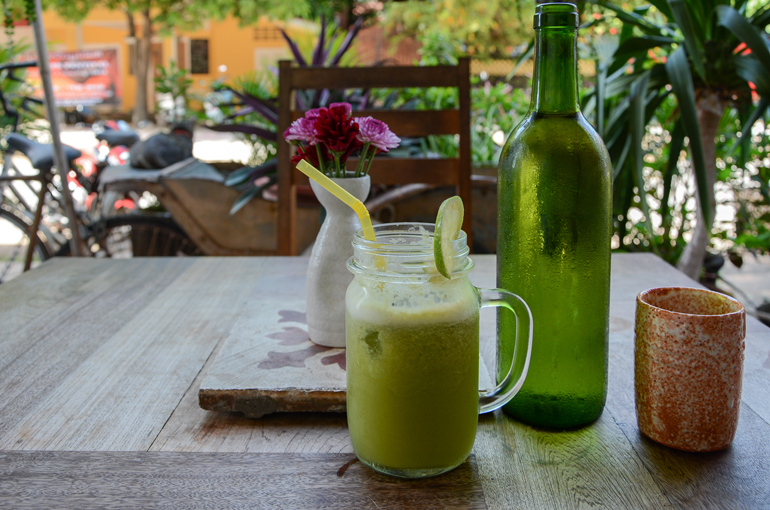 Ein grüner Smoothie steht in einem Cafe in Kampot bei Kambodscha auf einem Tisch.