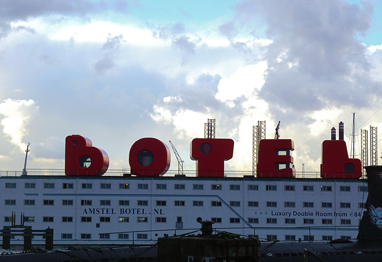 Auf dem Hotel-Schiff auf der NDSM-Werft in Amsterdam steht auf dem Dach in großen roten Buchstaben "botel" geschrieben.
