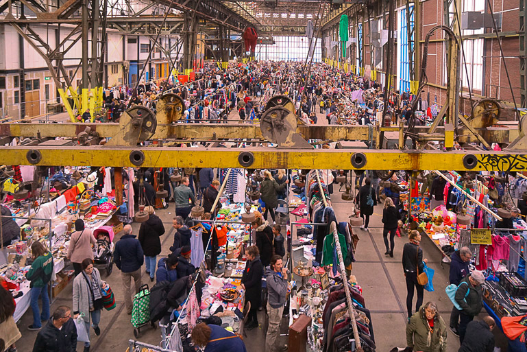 In der Ij-Halle in Amsterdam tummeln sich viele Menschen an Flohmarktständen.