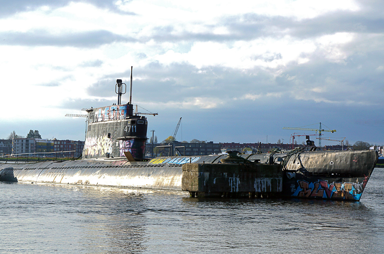 In einer alten, ehemaligen Schiffswerft in Amsterdam liegt ein halb gesunkenes mit Graffiti besprühtes U-Boot.