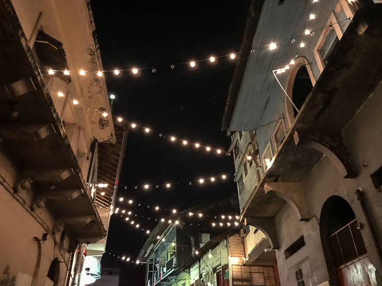 Lichterketten zwischen den Häuserfassaden beleuchten in der Nacht die Straßen von Panama Citys Altstadt.