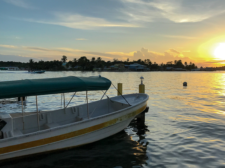 A water taxi floats in the water of Panama City overlooking Bocas del Toro in the evening sun.