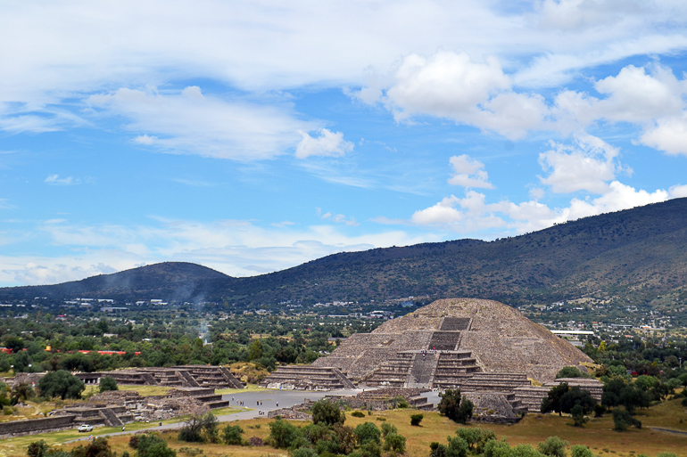Die Mondpyramide in Mexiko steht vor der bewachsenen Hügellandschaft Mexikos und weist ebenso zahlreiche steinerne Treppenstufen auf.