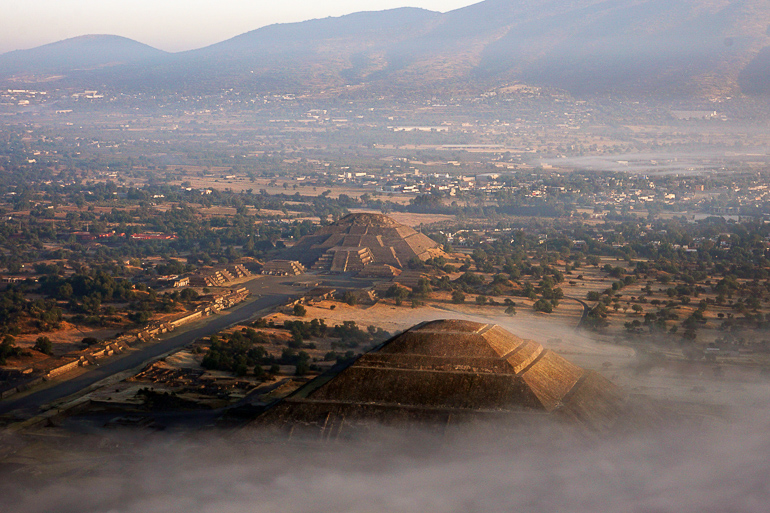 Aus der Vogelperspektive geht die Sonne über den Pyramiden von Mexiko auf und ein leichter Nebel verhüllt den Boden.