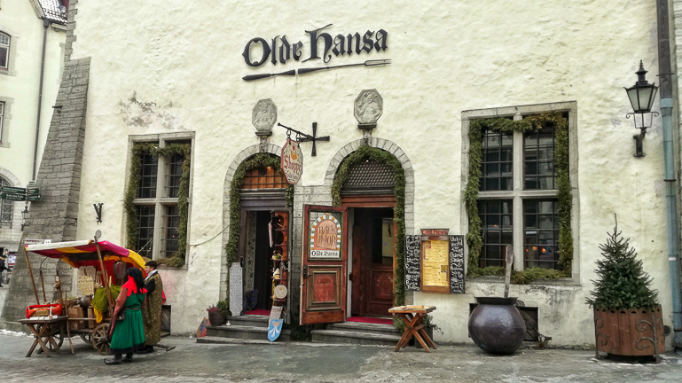 Vor der mittelalterlichen Fassade des Restaurant Olde Hansa in Tallinn steht ein mittlalterlicher Marktstand.