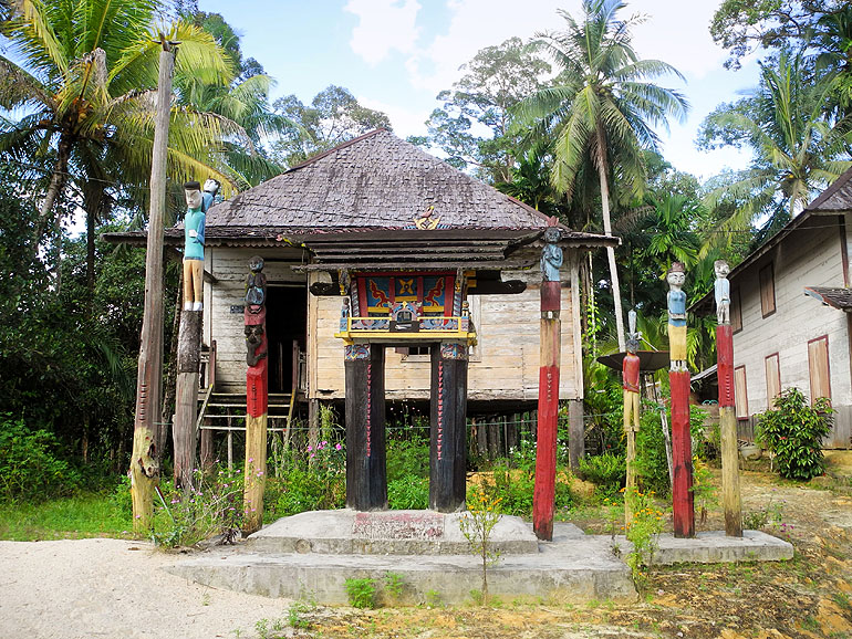Die Grabstätten auf Sandung sind mit bunten Holzstämmen geschmückt auf Borneo/Kalimantan.