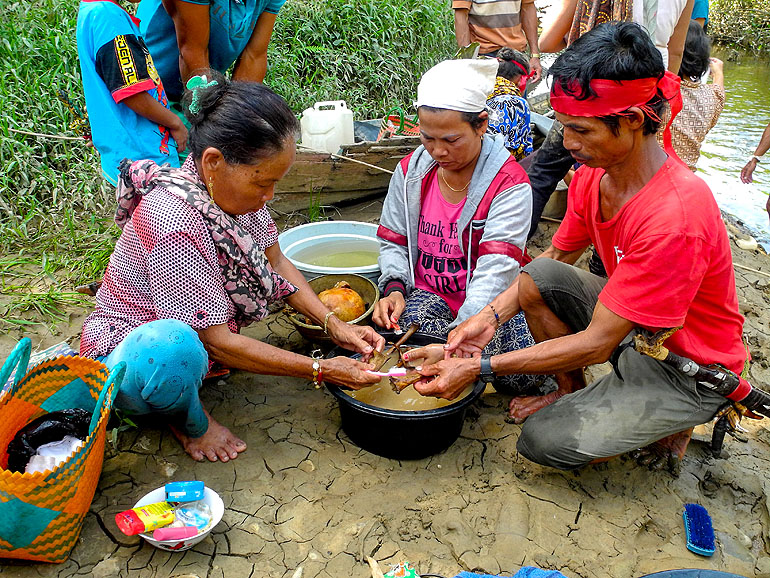 Auf Tiwah, Kalimantan reinigen Einheimische bei einer Zeremonie die Überreste eines Verstorbenen.