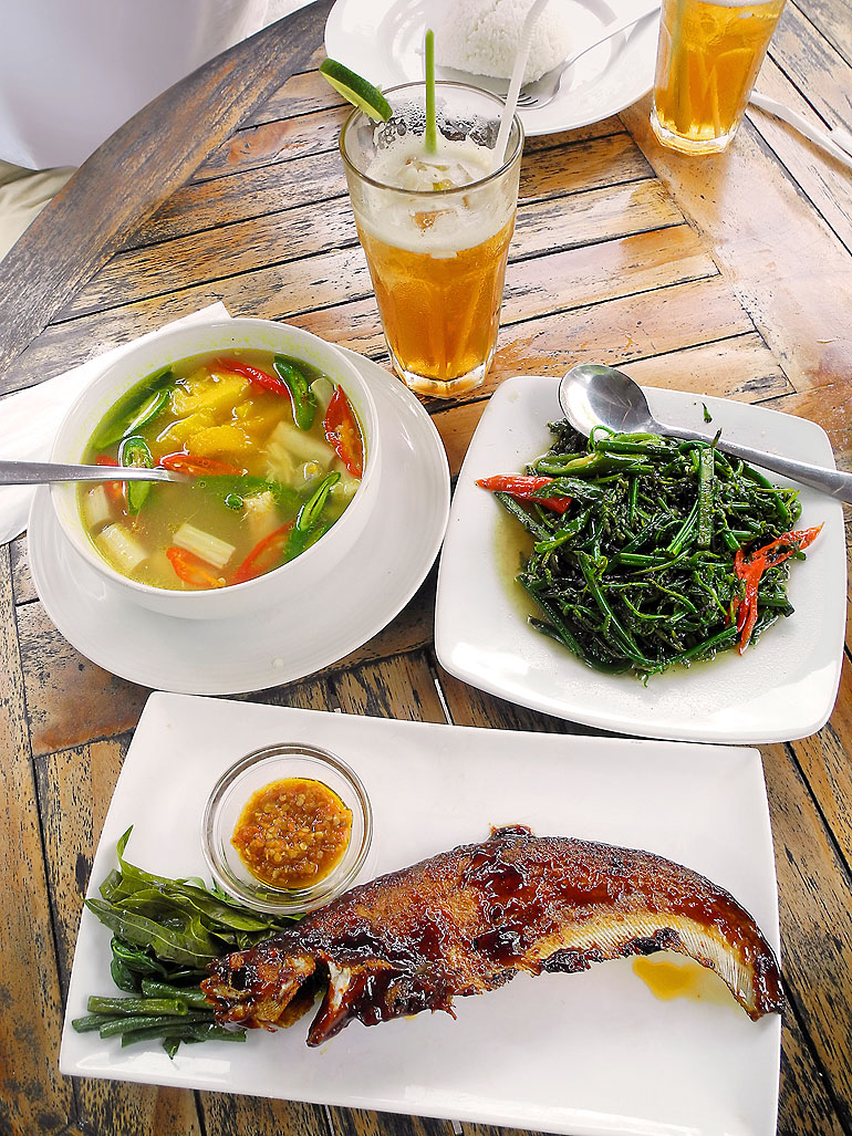 Auf einem Tisch im Tjilik Riwut Resto sind landestypische Speisen wie Rattansuppe, Bajei-Gemüse und gebratener Lais-Fisch angerichtet.