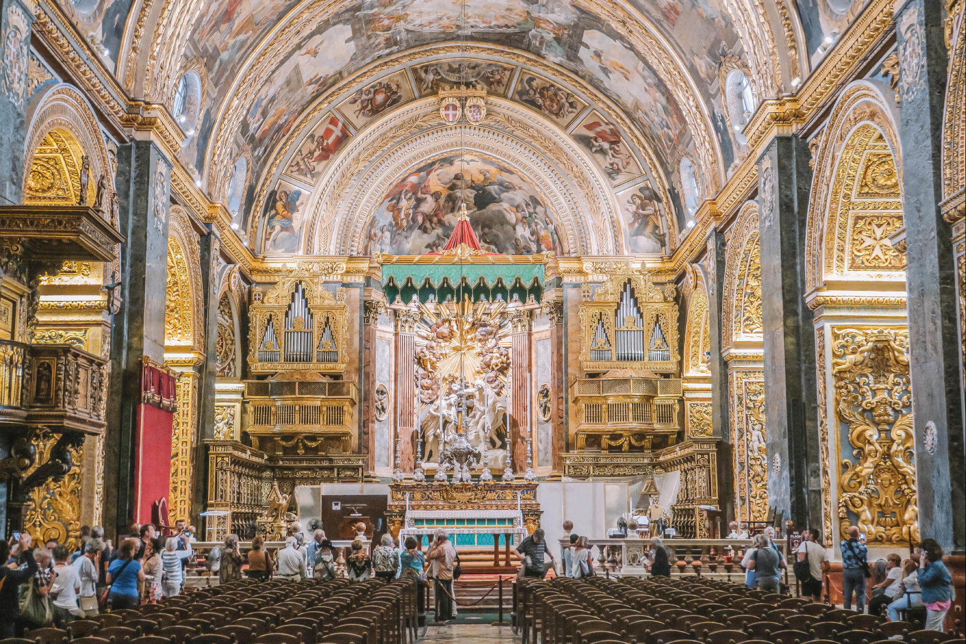 Eine Alte Kirche von Innen mit ein paar Menschen.