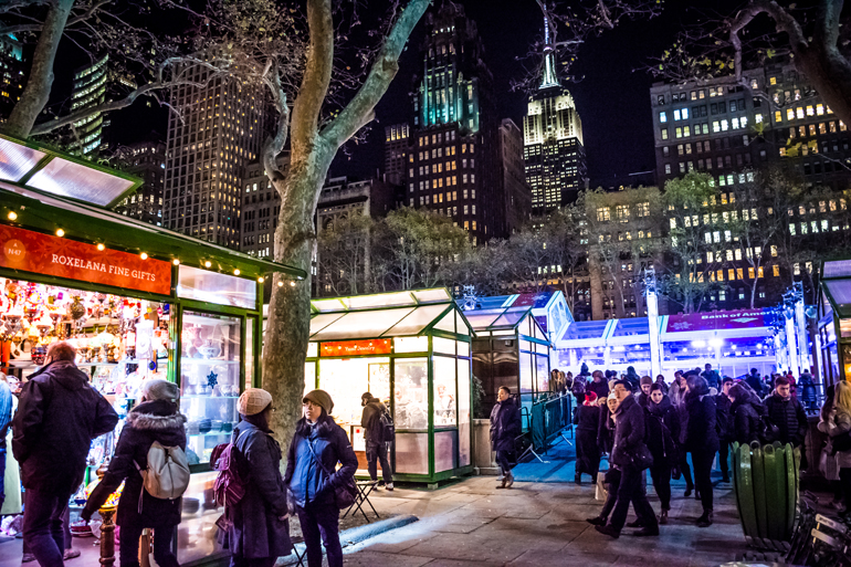 Im Bryant Park im New Yorker Stadtteil Manhattan bilden viele kleine Stände einen Wintermarkt, der Blick auf das Empire State Building lädt zum Verweile im Winter Village ein.