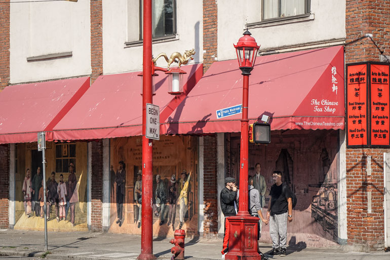 Vancouver: Red awnings adorn the walls of houses with graffiti in Chinatown, people are standing in front of them