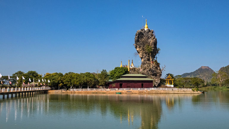 In Hpa An, Myanmar, steht ein Haus auf einer kleinen Insel mit einem riesigem Stein, die den Namen Kyauk Kalat Pagode trägt.