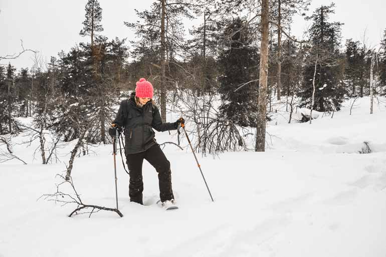 Eine Frau beim Schneeschuhwandern in Finnisch Lappland.