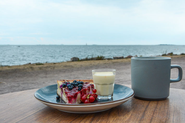 Helsinki: Beerenkuchen auf einem Teller mit einer Tasse neben dran.