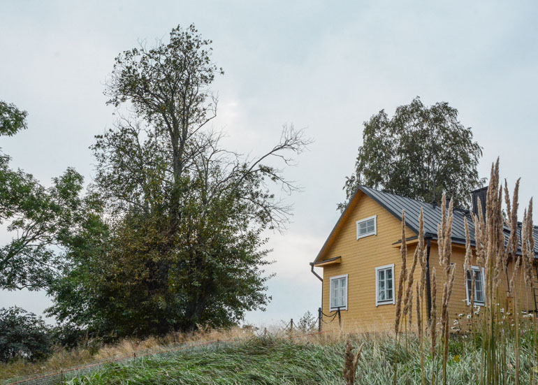 Helsinki: Gelbes Holzhaus auf einem kleinem Berg.