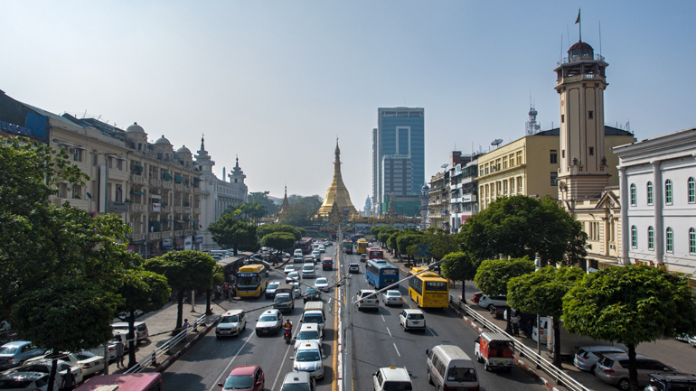 Die Aussicht auf die Sule Pagode entlang der vielbefahrenen Straßen in Downtown Yangon, Myanmar.