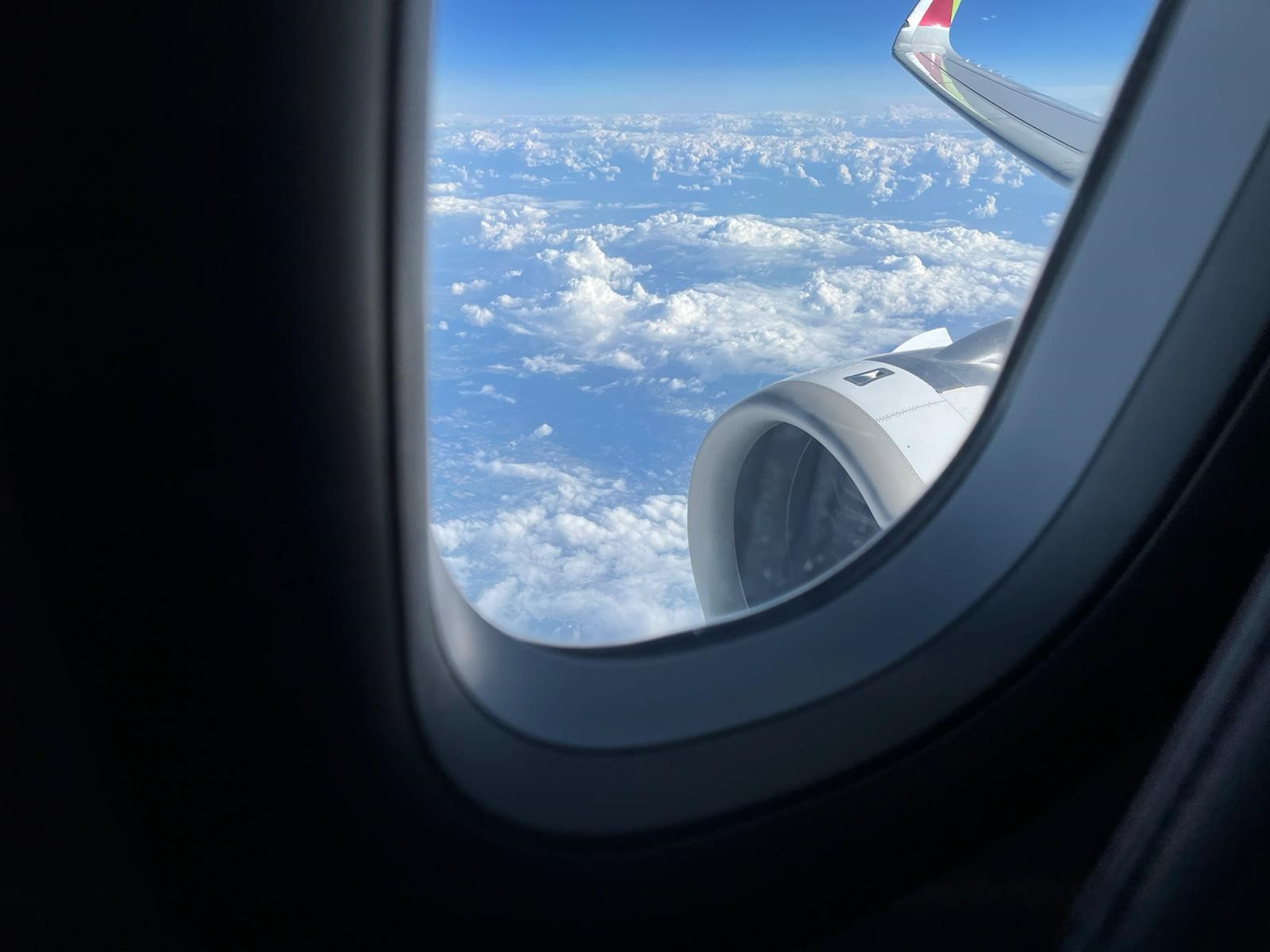 Blick aus einem Flugzeugfesnster über den Wolken.
