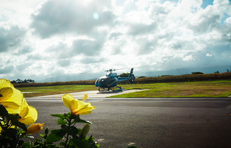 A blue helicopter takes off for a scenic flight over Kauai, Hawaii's garden island.