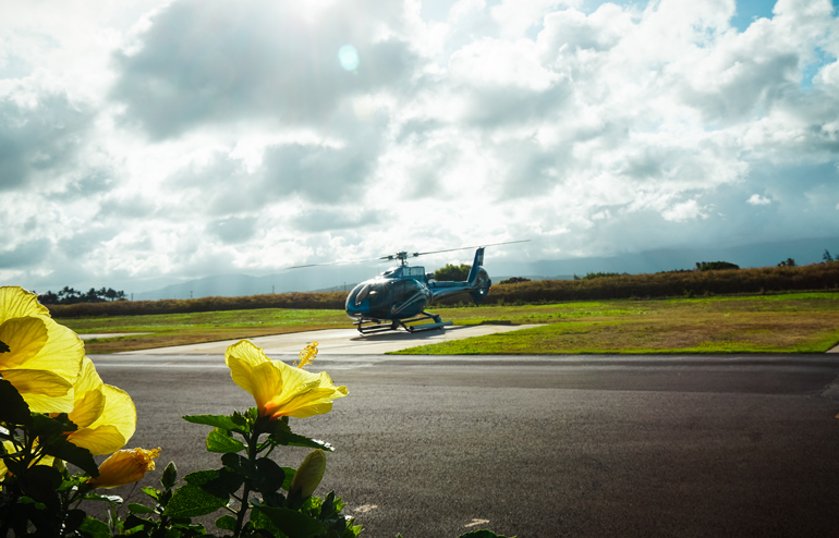 Ein blauer Helikopter setzt zum Rundflug über Kauai, Hawaiis Garteninsel, an.