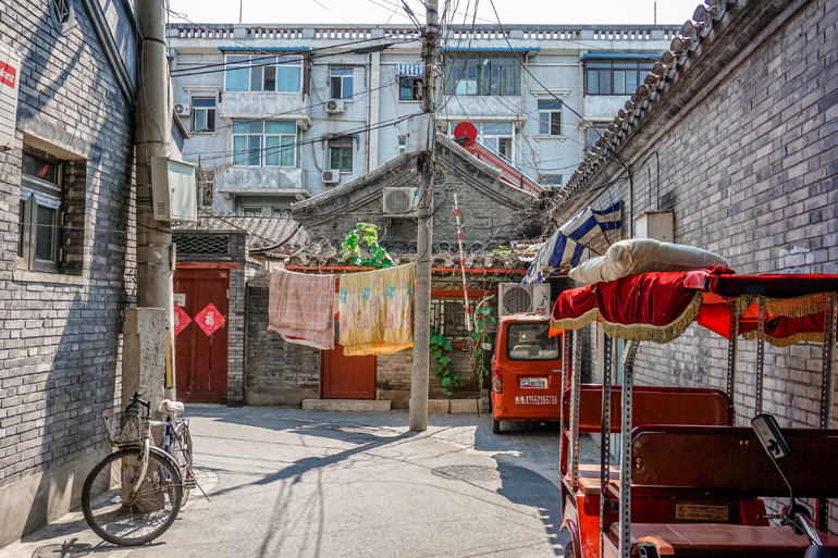Gasse mit bunten Fahrzeugen in Peking