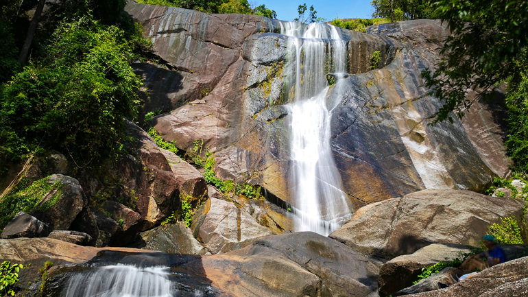 Malaysia: Wasserfall, der an einer Felswand herabfällt.