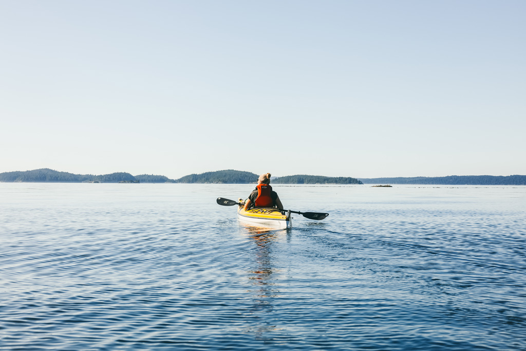 Kayaking Vancouver Island: Eine Frau von hinten auf einem Kajak.
