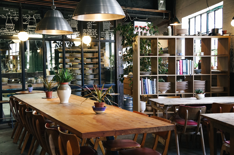 Ein Café mit einem großen Tisch in der Mitte.