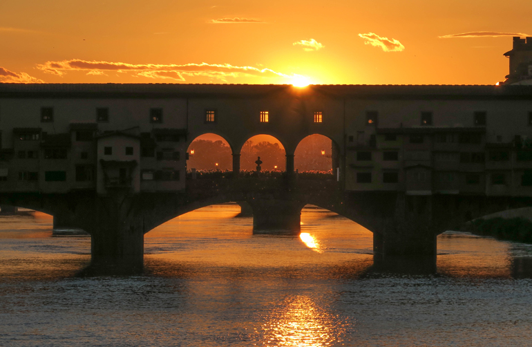Florenz Geheimtipps: Eine Brücke über einem Fluss im Sonnenuntergang.