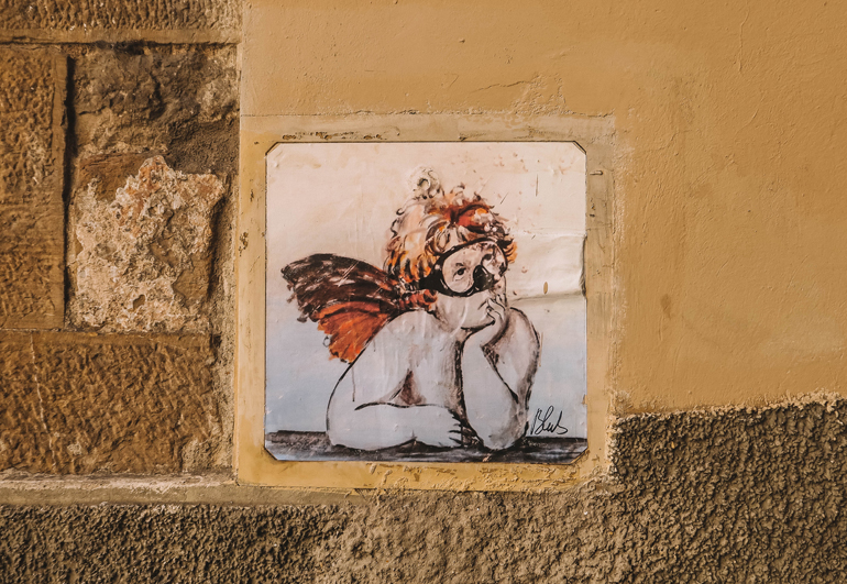 Florenz Geheimtipps: Eine Fliese in einer Mauer mit einem Engel darauf.