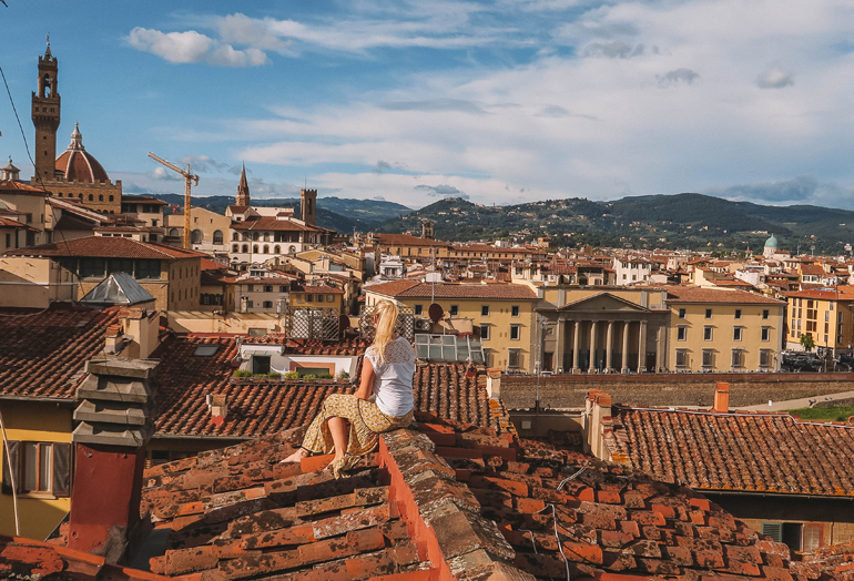 Florenz Geheimtipps: Eine Frau sitzt auf einem Dach.