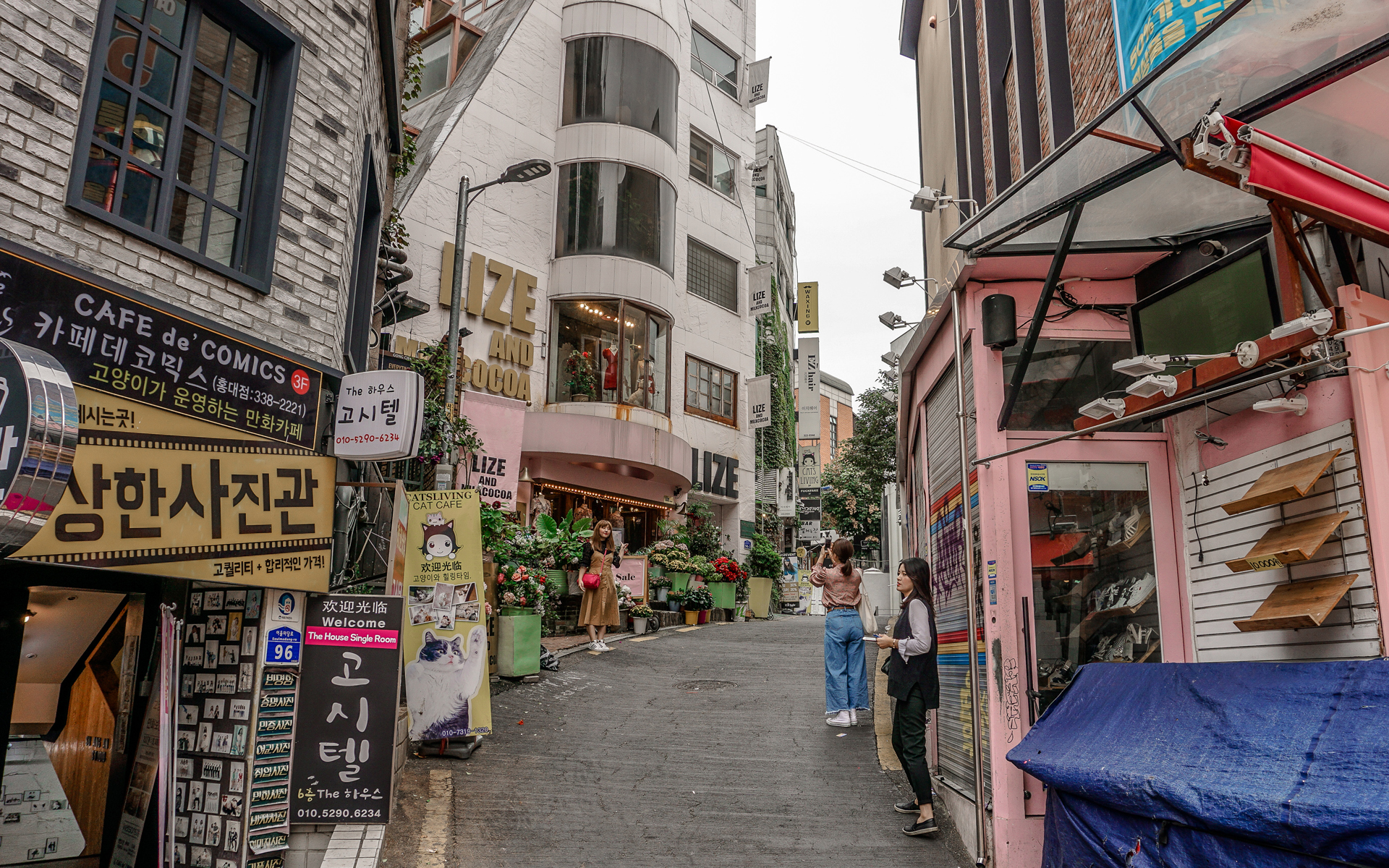 Sehenswüdigkeiten: Eine hippe Gasse in der Innenstadt von Seoul, eine Frau lässt sich fotografieren.
