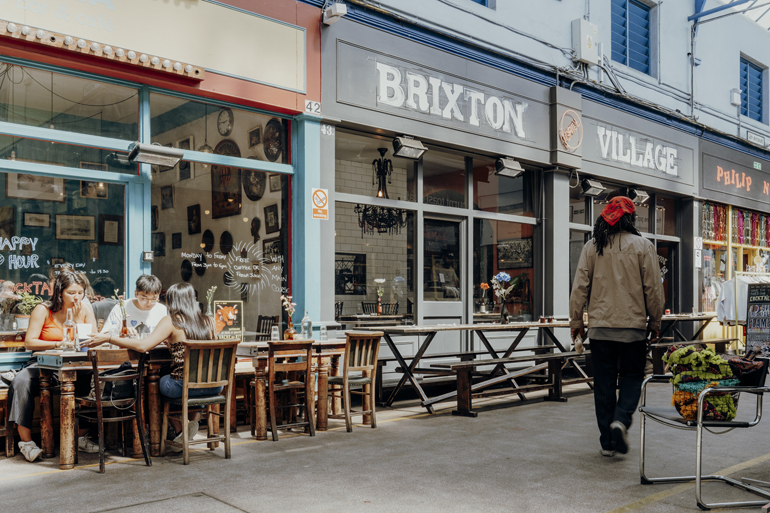Im Bixton Village in London kann man im Außenbereich der Restaurants das Essen im Karibik Flair genießen.