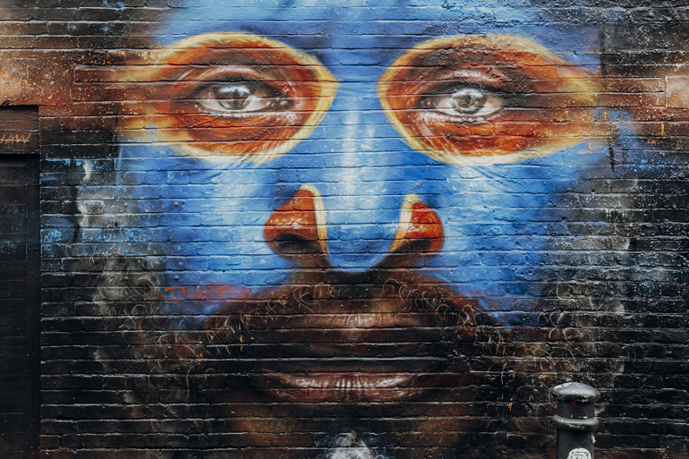 Das blaue Gesicht mit orange-gelb umrandeten Augen auf einer Wand in Shorreditch in London ist besonders beeindruckend.