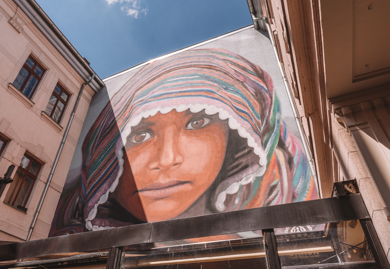 Budapest Städtetrip: Eine bemalte Wand auf der ein Gesicht mit einem Tuch zu sehen ist.