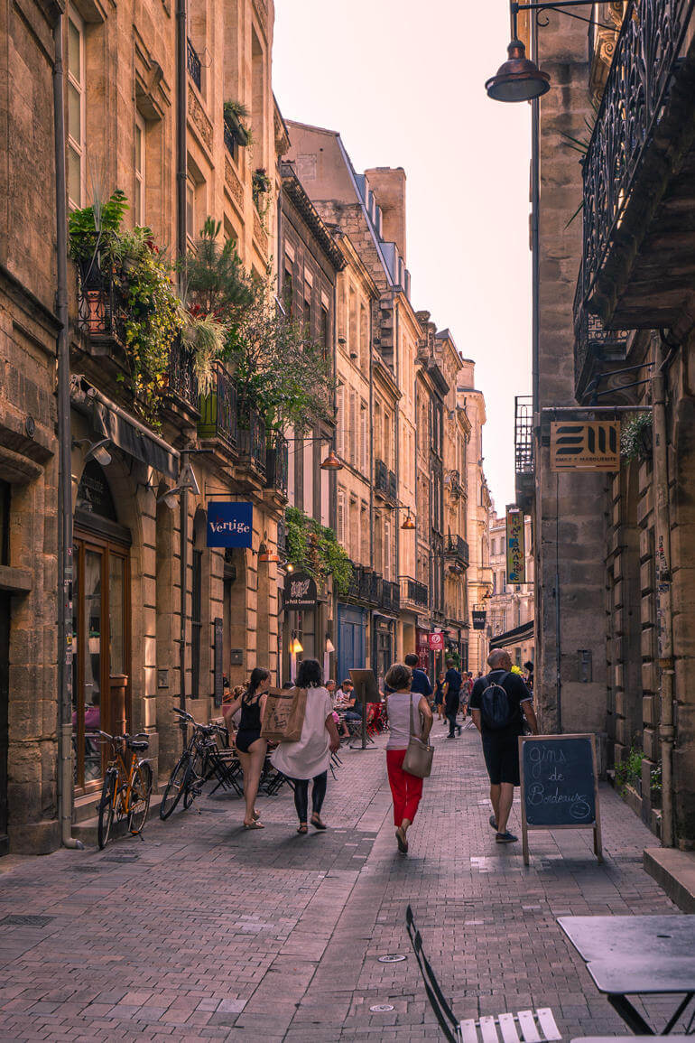 Städtetrip: Eine Gasse mit vielen alten Gebäuden und einigen Menschen.