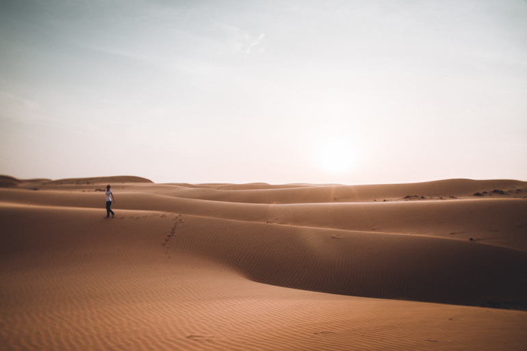 Oman Roadtrip; Reiseroute: Wüstenlandschaft mit einer laufenden Person.