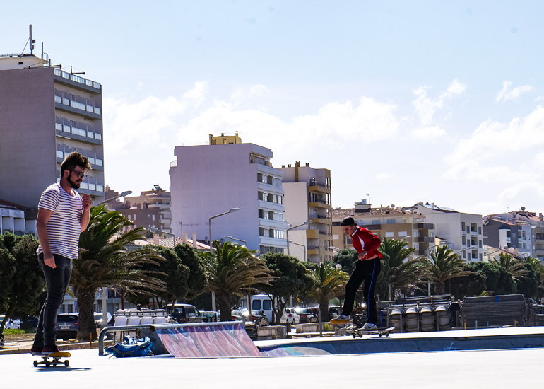 Skater auf einer Halfpipe, im Hintergrund Apartmenthäuser, in Buarcos, Portugal.