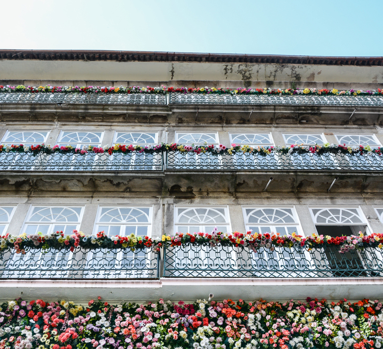 Porto Sehenswürdigkeiten: Ein Haus von unten, an dem die Balkone mit Blumen verziert sind.