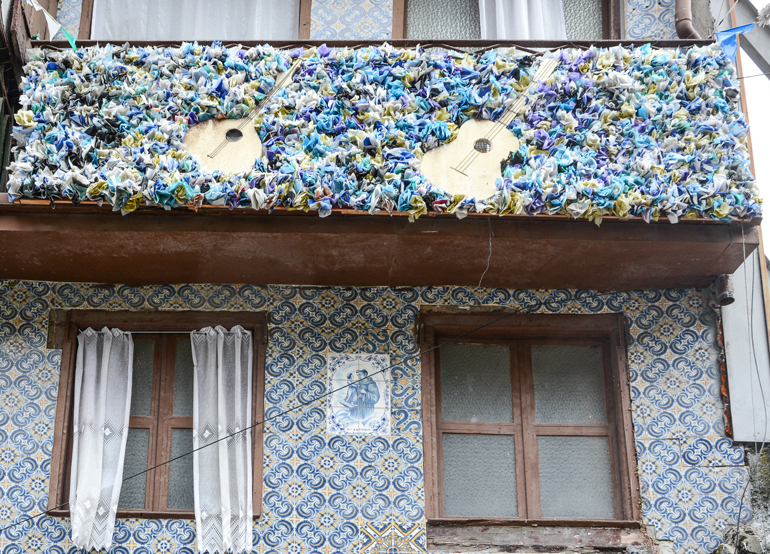 Porto Sehenswürdigkeiten: Ein Haus mit Fliesen an der Versace und einem Balkon der voller Blumen ist.
