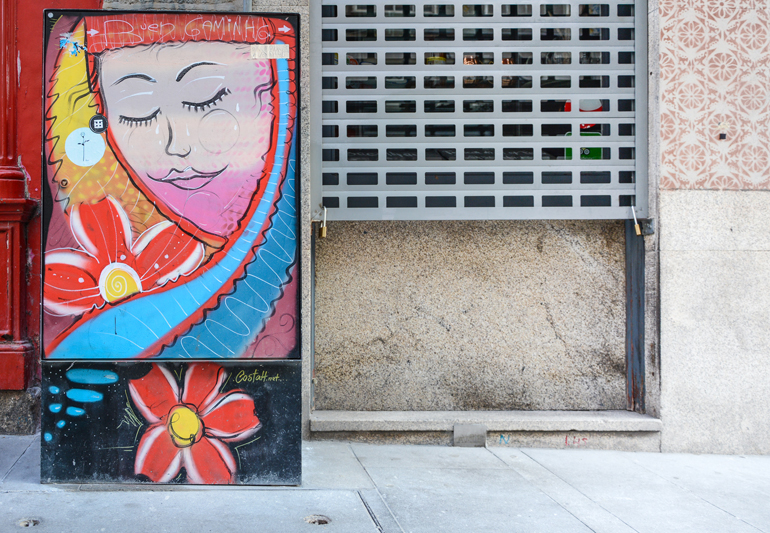 Porto Sehenswürdigkeiten: Eine bemalter Stromkaten auf dem ein Gesicht und Blumen zu sehen sind.