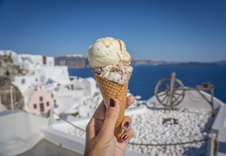 Eine Waffel mit Eis, im Hintergrund ist das Meer und die Stadt zu sehen.